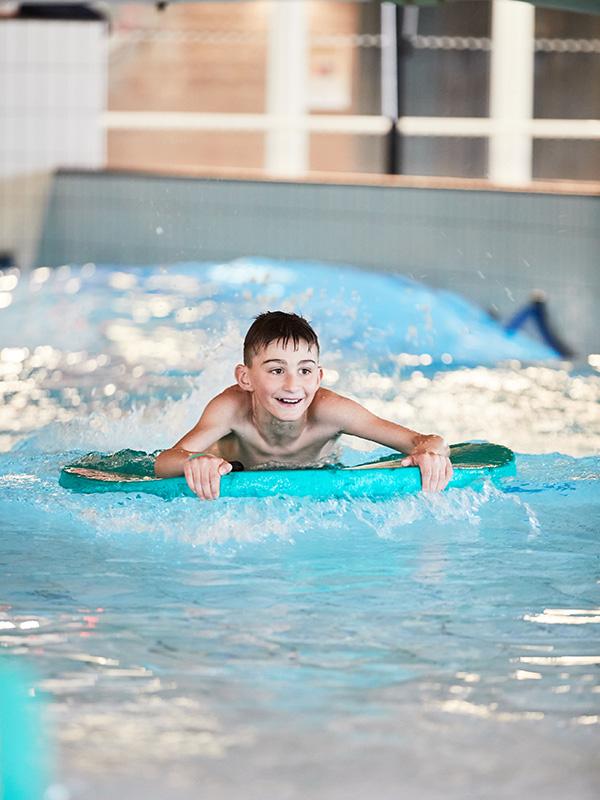 Kille på flytleksak i pool