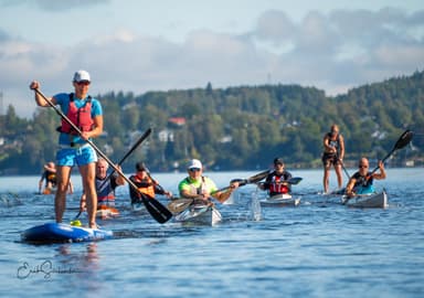 En grupp människor på SUP:ar, kanoter osv i Viskan.