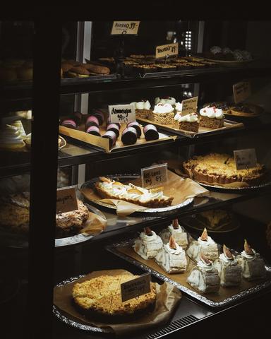 Ett vitrinskåp fyllt med massor av olika sorters tårtor.