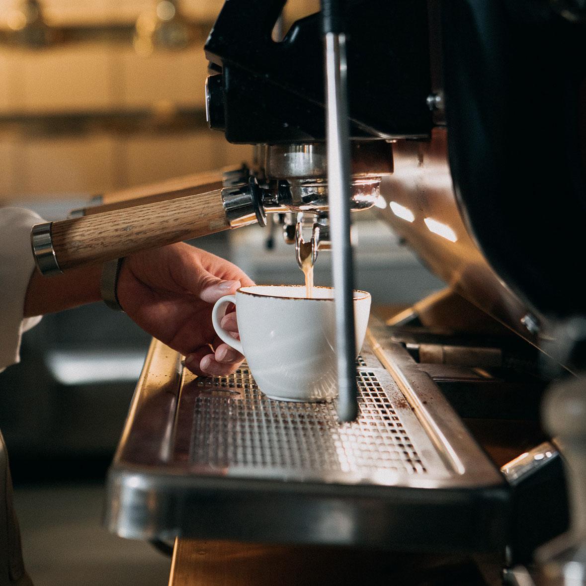 En kopp kaffe tillreds i en espressomaskin.