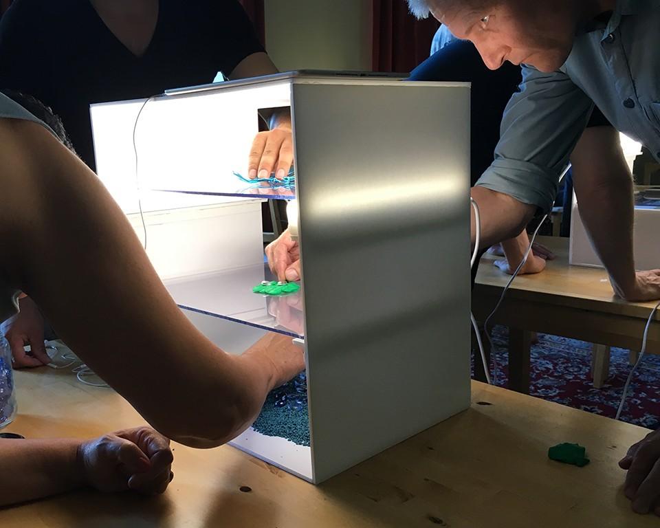 Människor som flyttar föremål i en ljusbox