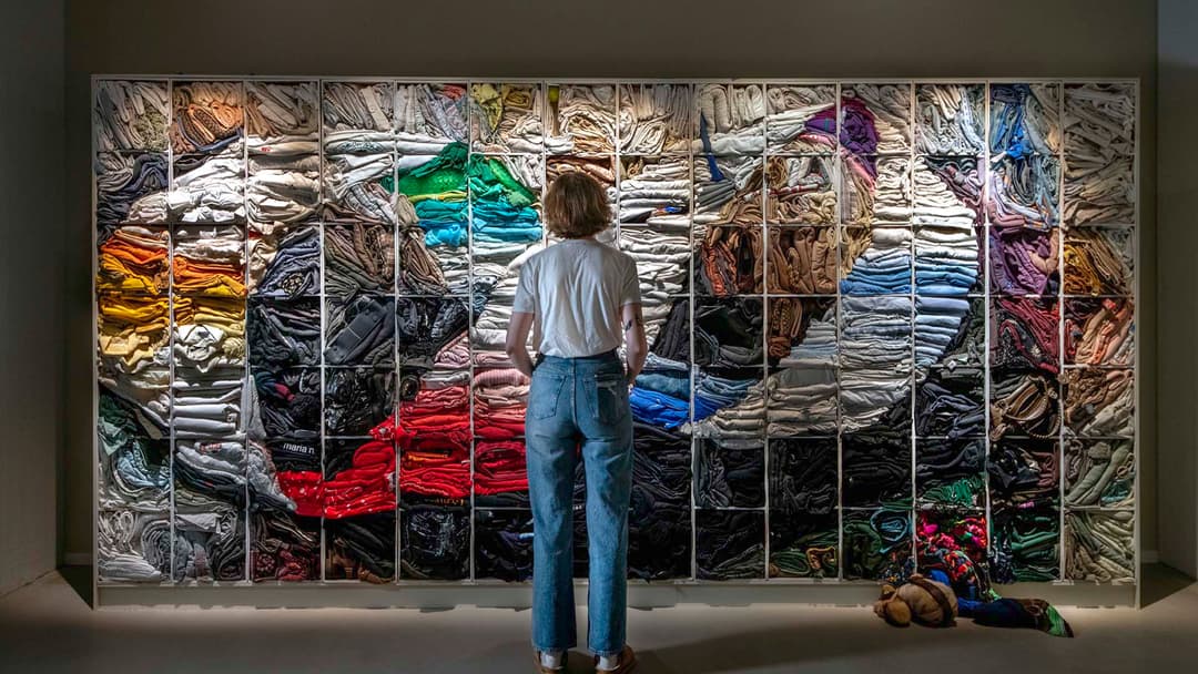 En person tittar på ett konstverk föreställande en liggande 8:a av textil