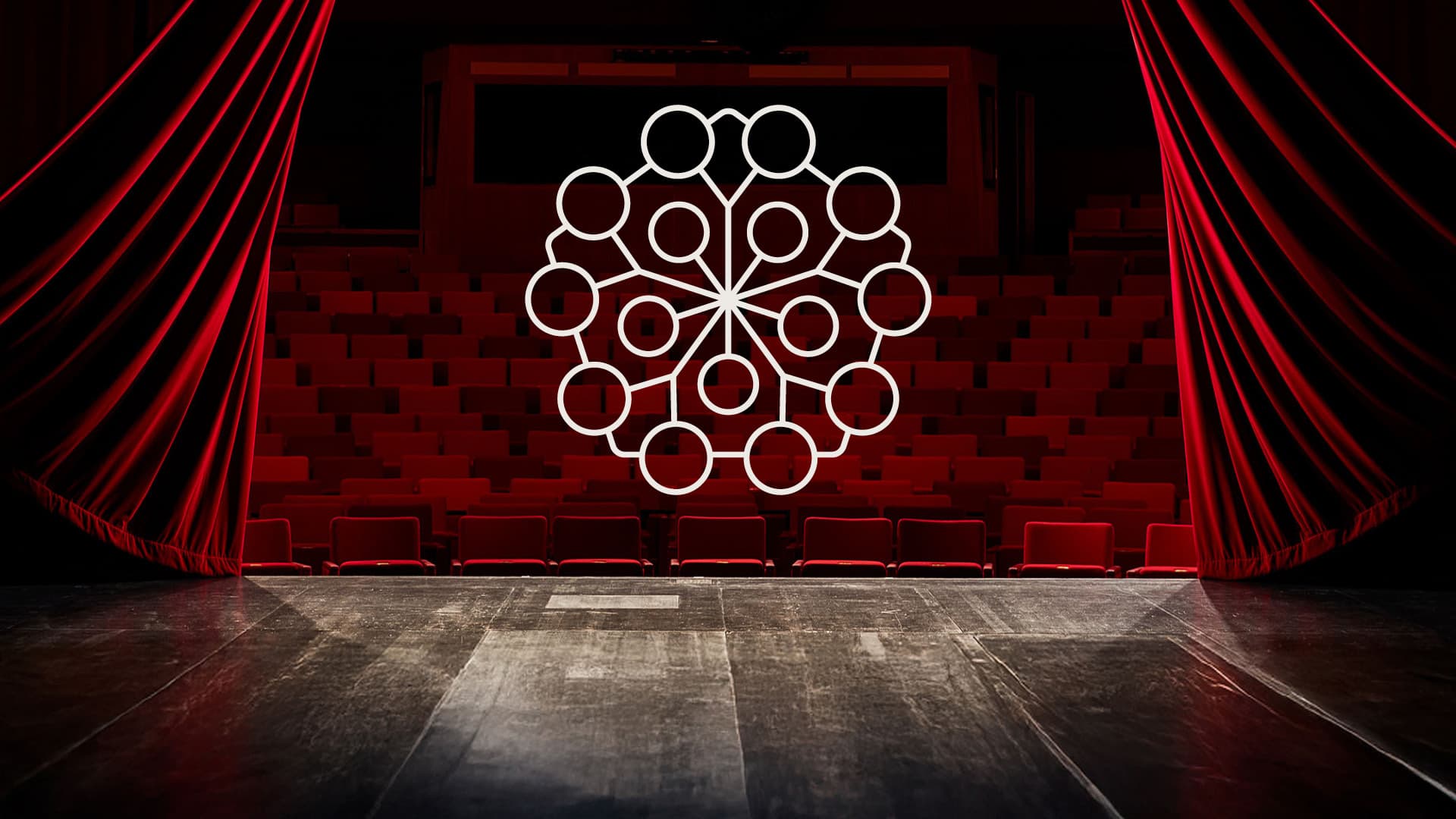 Teatersalong med röda stolar sedd från scenen, med Borås Stadsteaters logotyp i mitten.