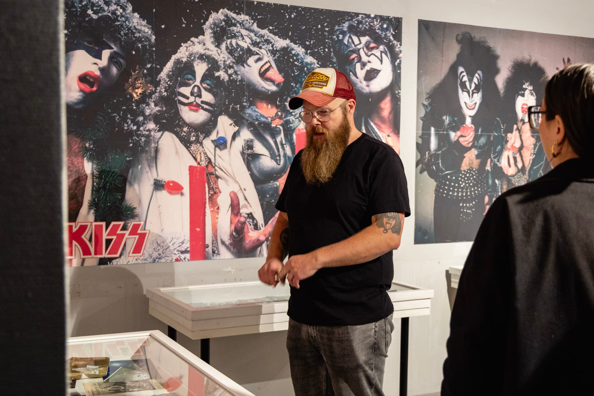 En man guidar inne på en Kiss-utställning.