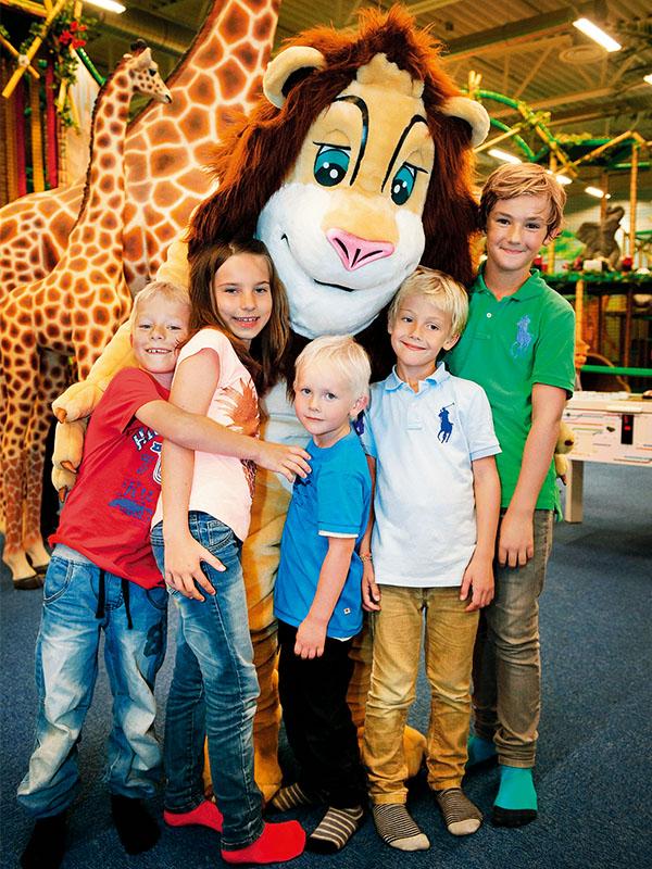 En grupp barn kramar Leos maskots